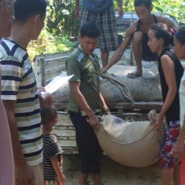 rejoice and others giving out rice to local villagers