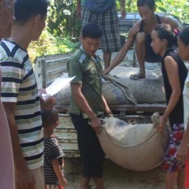 rejoice and others giving out rice to local villagers